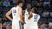 Memphis Grizzlies guard Ja Morant (12) talks with center Zach Edey (14) and forward Jaren Jackson Jr. (13) 