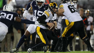 Sep 23, 2023; University Park, Pennsylvania, USA; Iowa Hawkeyes quarterback Cade McNamara (12) scrambles with the ball while avoiding a tackle during the first quarter against the Penn State Nittany Lions at Beaver Stadium. Penn State defeated Iowa 31-0. Mandatory Credit: Matthew O'Haren-USA TODAY Sports