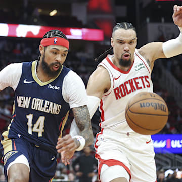 Jan 31, 2024; Houston, Texas, USA; New Orleans Pelicans forward Brandon Ingram (14) and Houston Rockets forward Dillon Brooks (9) attempt to get a loose ball during the game at Toyota Center. 