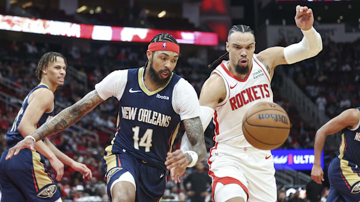 Jan 31, 2024; Houston, Texas, USA; New Orleans Pelicans forward Brandon Ingram (14) and Houston Rockets forward Dillon Brooks (9) attempt to get a loose ball during the game at Toyota Center. 