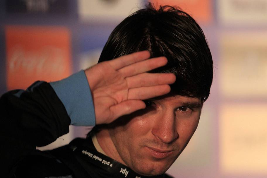 Lionel Messi shielding his eyes.