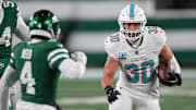 Miami Dolphins fullback Alec Ingold (30) runs with the ball during the second half as New York Jets cornerback D.J. Reed (4) pursues at MetLife Stadium. 
