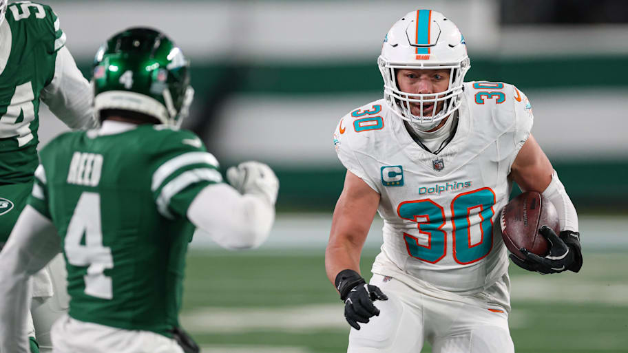 Miami Dolphins fullback Alec Ingold (30) runs with the ball during the second half as New York Jets cornerback D.J. Reed (4) pursues at MetLife Stadium.  | Vincent Carchietta-Imagn Images