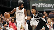 Dallas Mavericks guard Kyrie Irving controls the ball as San Antonio Spurs guard Stephon Castle defends.