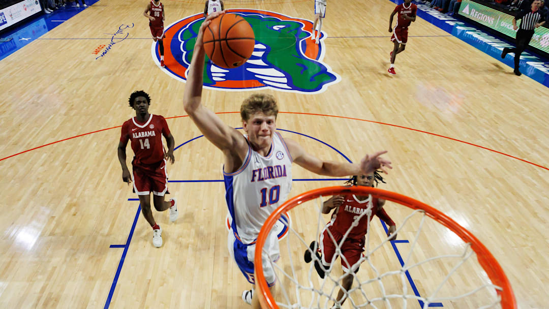 Feb 1, 2026; Gainesville, Florida, USA; Florida Gators forward Thomas Haugh (10) dunks the ball over Alabama Crimson Tide guard Latrell Wrightsell Jr. (3) and Alabama Crimson Tide center Charles Bediako (14) during the second half at Exactech Arena at the Stephen C. O'Connell Center. Mandatory Credit: Matt Pendleton-Imagn Images