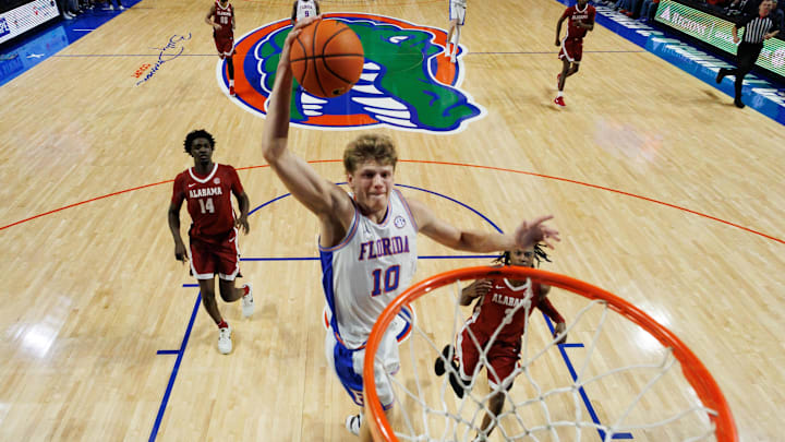 Feb 1, 2026; Gainesville, Florida, USA; Florida Gators forward Thomas Haugh (10) dunks the ball over Alabama Crimson Tide guard Latrell Wrightsell Jr. (3) and Alabama Crimson Tide center Charles Bediako (14) during the second half at Exactech Arena at the Stephen C. O'Connell Center. Mandatory Credit: Matt Pendleton-Imagn Images