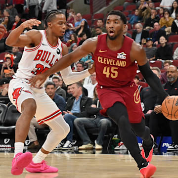 Oct 9, 2025; Chicago, Illinois, USA; Cleveland Cavaliers guard Donovan Mitchell (45) drives against Chicago Bulls forward/guard Isaac Okoro (35) during the first half at United Center. Mandatory Credit: Patrick Gorski-Imagn Images