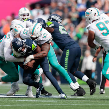 Seattle Seahawks quarterback Geno Smith (7) is sacked by Miami Dolphins defensive tackle Da'Shawn Hand (90) during the first quarter at Lumen Field.