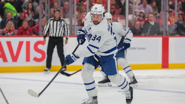 Hockey player in white uniform shoots the puc