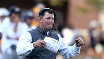 A former head coach is stepping back into a head coaching role for his current employer.