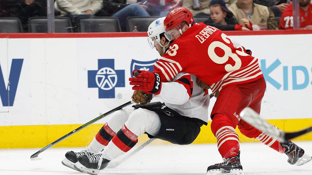 Apr 11, 2026; Detroit, Michigan, USA;  New Jersey Devils center Nico Hischier (13) and Detroit Red Wings right wing Alex DeBrincat (93) battle for the puck in the third period at Little Caesars Arena. Mandatory Credit: Rick Osentoski-Imagn Images