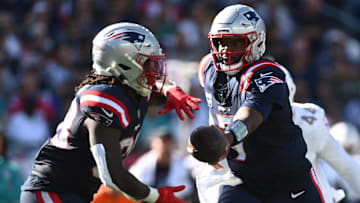 Oct 6, 2024; Foxborough, Massachusetts, USA; New England Patriots quarterback Jacoby Brissett (7) hands the ball off to running back Rhamondre Stevenson (38) during the second half at Gillette Stadium. Mandatory Credit: Brian Fluharty-Imagn Images