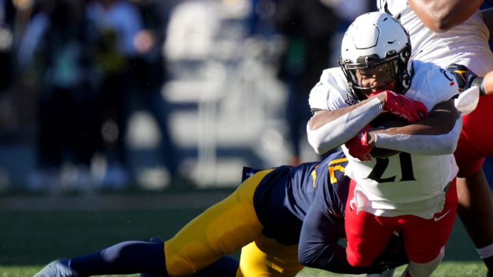 Cincinnati Bearcats running back Corey Kiner (21) carries the ball in the first quarter during an NCAA college football game between the Cincinnati Bearcats and the West Virginia Mountaineers, Saturday, Nov. 18, 2023, at Milan Puskar Stadium in Morgantown, W. Va.