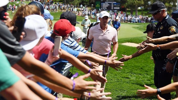 Rory McIlroy slaps hands with fans as he leaves the 15th green during the third round of the 2024 BMW Championship.