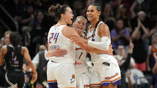 A photo of Kathryn Westbeld, Lexi Held, and Satou Sabally celebratin