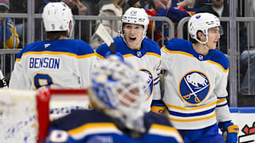 Dec 29, 2024; St. Louis, Missouri, USA;  Buffalo Sabres center Jiri Kulich (20) is congratulated by defenseman Dennis Gilbert (8) and center Peyton Krebs (19) after scoring against St. Louis Blues goaltender Jordan Binnington (50) during the third period at Enterprise Center. Mandatory Credit: Jeff Curry-Imagn Images