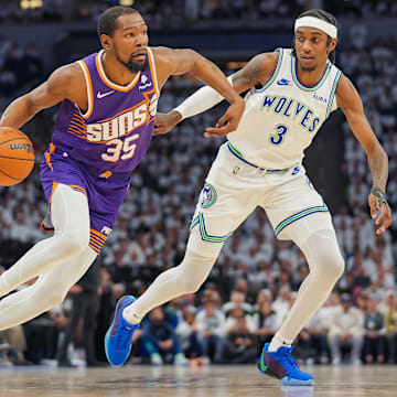 Apr 23, 2024; Minneapolis, Minnesota, USA; Phoenix Suns forward Kevin Durant (35) dribbles against Minnesota Timberwolves forward Jaden McDaniels (3) in the second quarter during game two of the first round for the 2024 NBA playoffs at Target Center.