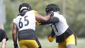 Jul 27, 2023; Latrobe, PA, USA;  Pittsburgh Steelers offensive tackle Dan Moore Jr. (65) works against offensive tackle Broderick Jones (77) in drills during training camp at Saint Vincent College. Mandatory Credit: Charles LeClaire-Imagn Images