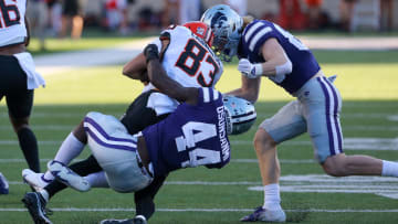 Oct 29, 2022; Manhattan, Kansas, USA; Oklahoma State Cowboys wide receiver Cale Cabbiness (83) is tackled by Kansas State Wildcats linebacker Tobi Osunsanmi (44) and wide receiver Ty Bowman (80) during the fourth quarter at Bill Snyder Family Football Stadium. Mandatory Credit: Scott Sewell-USA TODAY Sports