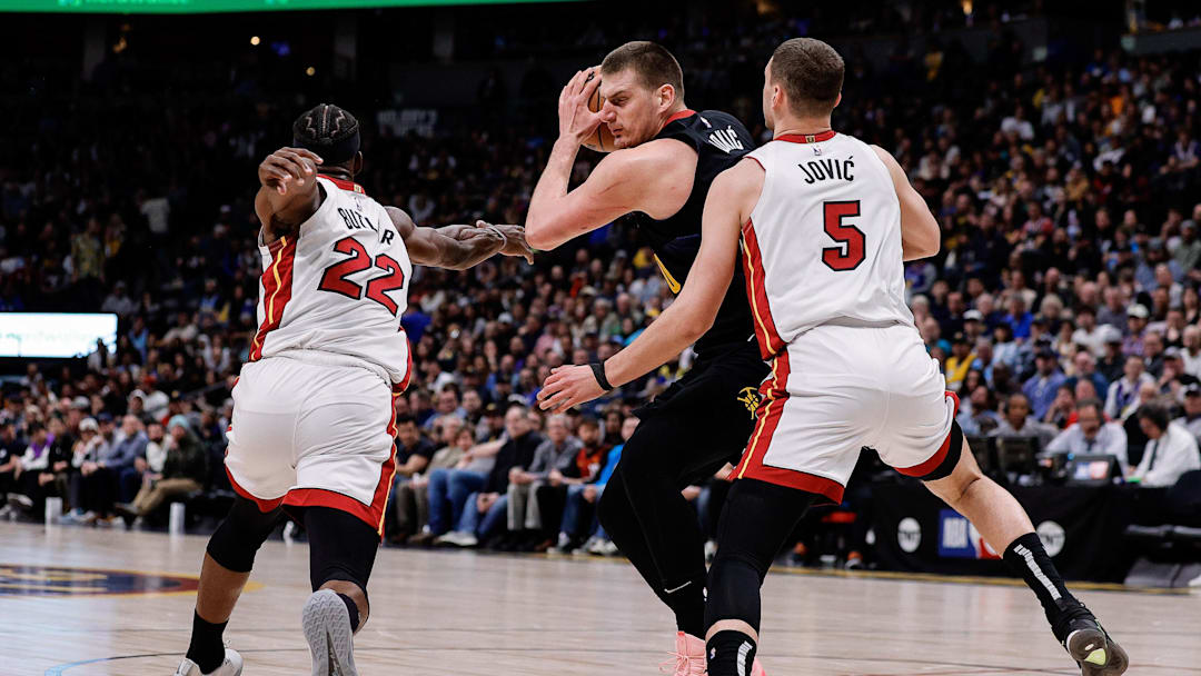 Feb 29, 2024; Denver, Colorado, USA; Denver Nuggets center Nikola Jokic (15) controls the ball under pressure from Miami Heat forward Jimmy Butler (22) and forward Nikola Jovic (5) in the second quarter at Ball Arena. Mandatory Credit: Isaiah J. Downing-Imagn Images