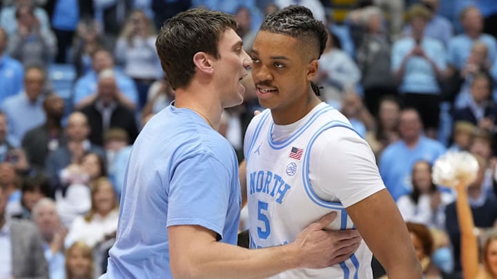 Jan 21, 2023; Chapel Hill, North Carolina, USA; Former North Carolina Tar Heels great Tyler Hansbrough presents forward Armando Bacot (5) with the game ball after the game. Bacot became the all-time Tar Heels rebounding leader during the game breaking Hansbrough   s record. Mandatory Credit: Bob Donnan-Imagn Images