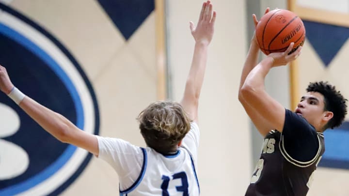 Highlands guard Preston Foster, right, shoots over Burrell's Gavyn Orr during a Section 1-4A game Friday night at Burrell High School. Smith finished with 10 points and the Golden Rams won 40-35.