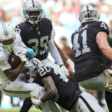 Nov 19, 2023; Miami Gardens, Florida, USA; Miami Dolphins wide receiver Robbie Chosen (3) is tackled by Las Vegas Raiders safety Isaiah Pola-Mao (20) during the second quarter at Hard Rock Stadium.