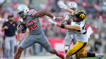 Oct 5, 2024; Columbus, OH, USA; Ohio State Buckeyes running back TreVeyon Henderson (32) fights off the tackle attempt by Iowa Hawkeyes defensive back Quinn Schulte (30) during the second half of the NCAA football game at Ohio Stadium. Ohio State won 35-7.
