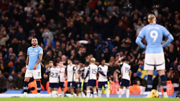 Spurs players celebrate against Manchester City - with dejected Kyle Walker and Erling Haaland looking on