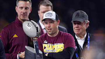 Dec 7, 2024; Arlington, TX, USA; Arizona State Sun Devils head coach Kenny Dillingham looks at the trophy after winning the Big 12 Championship game against the Iowa State Cyclones at AT&T Stadium. Mandatory Credit: Tim Heitman-Imagn Images