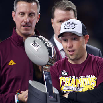 Dec 7, 2024; Arlington, TX, USA; Arizona State Sun Devils head coach Kenny Dillingham looks at the trophy after winning the Big 12 Championship game against the Iowa State Cyclones at AT&T Stadium. Mandatory Credit: Tim Heitman-Imagn Images