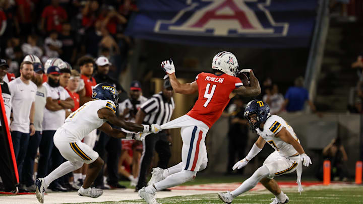 Sep 7, 2024; Tucson, Arizona, USA; Northern Arizona Lumberjacks center back DJ Vanhook (4) attempts to tackle Arizona Wildcats wide receiver Tetairoa McMillan (4) during the third quarter at Arizona Stadium.