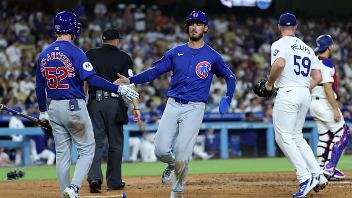 Sep 10, 2024; Los Angeles, California, USA;  Chicago Cubs right fielder Cody Bellinger (24) greets by center fielder Pete Crow-Armstrong (52) after scoring a run during the eighth inning against the Los Angeles Dodgers at Dodger Stadium. Mandatory Credit: Kiyoshi Mio-Imagn Images