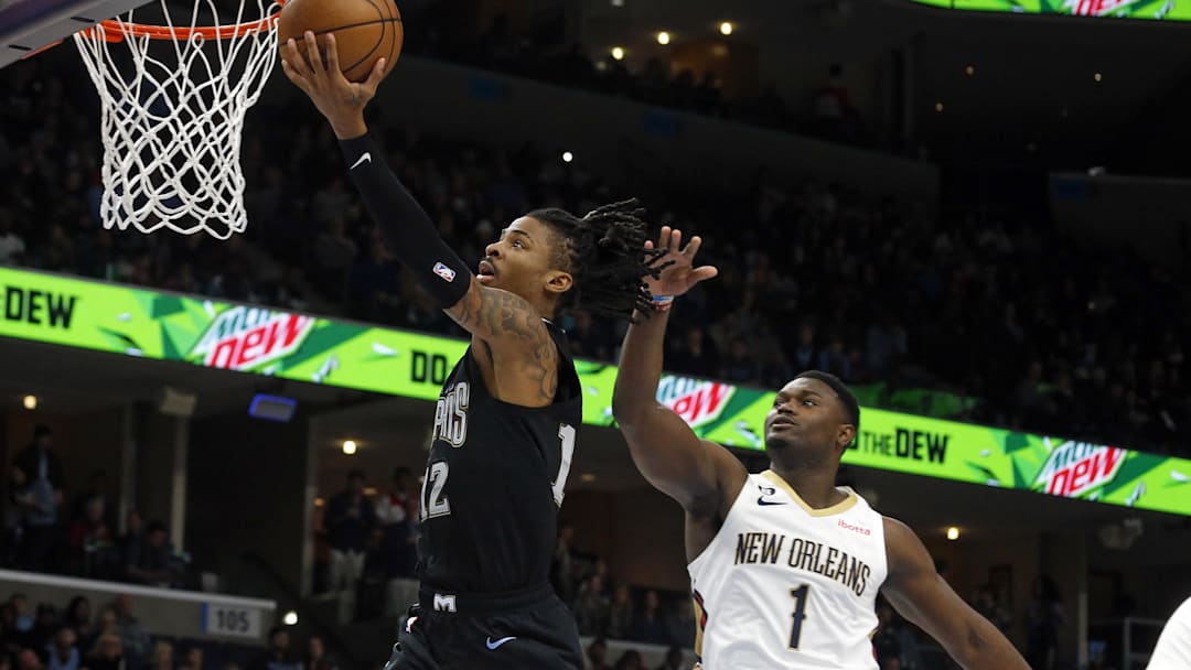 Nov 25, 2022; Memphis, Tennessee, USA; Memphis Grizzlies guard Ja Morant (12) drives to the basket as New Orleans Pelicans forward Zion Williamson (1) defends during the first quarter at FedExForum. Mandatory Credit: Petre Thomas-Imagn Images