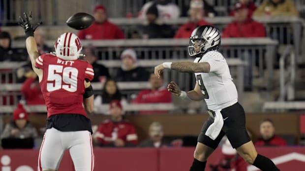 Oregon quarterback Dillon Gabriel (8) is pressured by Wisconsin linebacker Aaron Witt (59) during the first quarter