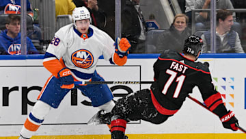 Mar 19, 2024; Elmont, New York, USA; New York Islanders defenseman Alexander Romanov (28) checks Carolina Hurricanes right wing Jesper Fast (71) during the first period at UBS Arena. Mandatory Credit: Dennis Schneidler-Imagn Images