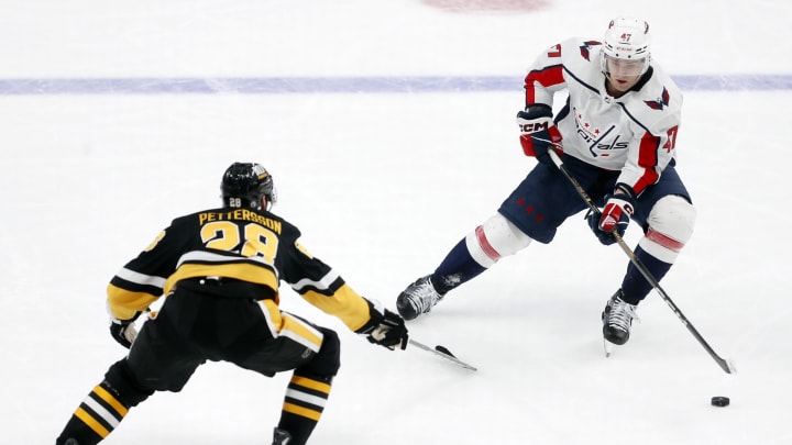 Mar 7, 2024; Pittsburgh, Pennsylvania, USA; Washington Capitals left wing Beck Malenstyn (47) moves the puck as Pittsburgh Penguins defenseman Marcus Pettersson (28) defends during the third period at PPG Paints Arena. The Capitals shutout the Penguins 6-0. Mandatory Credit: Charles LeClaire-USA TODAY Sports