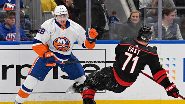 Mar 19, 2024; Elmont, New York, USA; New York Islanders defenseman Alexander Romanov (28) checks Carolina Hurricanes right wing Jesper Fast (71) during the first period at UBS Arena. Mandatory Credit: Dennis Schneidler-Imagn Images