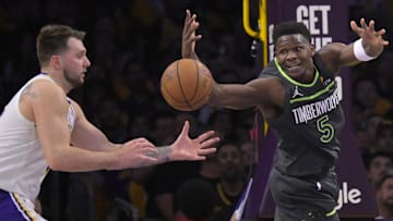 Apr 19, 2025; Los Angeles, California, USA; Los Angeles Lakers guard Luka Doncic (77) and Minnesota Timberwolves guard Anthony Edwards (5) reach for a loose ball in the first half at Crypto.com Arena. Mandatory Credit: Jayne Kamin-Oncea-Imagn Images