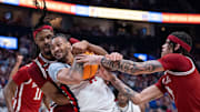 Arkansas Razorbacks forward Jonas Aidoo (9) guards Ole Miss Rebels guard Dre Davis (14) while Arkansas Razorbacks guard Trevon Brazile (4) defends during their second round game of the SEC Men's Basketball Tournament at Bridgestone Arena in Nashville.