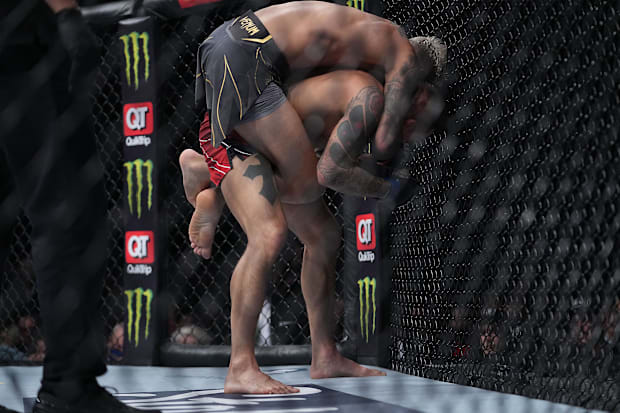 Charles Oliveira locks in a choke against Dustin Poirier during UFC 269 at T-Mobile Arena. 