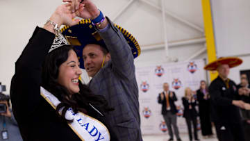 Ashley Rios, the Lady in Waiting for the 2024 Sun Court, dances with Jedd Fisch, Washington's head football coach, as he arrived in El Paso on Thursday, Dec. 26, 2024, for the 2024 Tony the Tiger Sun Bowl.