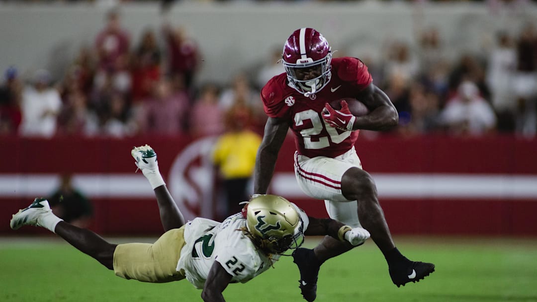 Sep 7, 2024; Tuscaloosa, Alabama, USA;  South Florida Bulls cornerback De'Shawn Rucker (22) dives for Alabama Crimson Tide running back Jam Miller (26) as he carries the ball down the field during the third quarter at Bryant-Denny Stadium. Mandatory Credit: William McLelland-Imagn Images