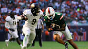 Nov 23, 2024; Miami Gardens, Florida, USA; Miami Hurricanes tight end Elijah Arroyo (8) runs with the football as Wake Forest Demon Deacons linebacker Quincy Bryant (9) attempts a tackle during the second quarter at Hard Rock Stadium. 