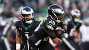 Nov 28, 2025; Philadelphia, Pennsylvania, USA; Philadelphia Eagles quarterback Jalen Hurts (1) hands the ball to Philadelphia Eagles running back Saquon Barkley (26) against the Chicago Bears during the second quarter of the game at Lincoln Financial Field. Mandatory Credit: Bill Streicher-Imagn Images
