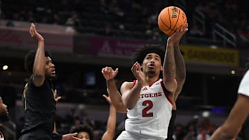 Mar 12, 2025; Indianapolis, IN, USA; Rutgers Scarlet Knights guard Dylan Harper (2) scores past USC Trojans guard Chibuzo Agbo (7) during the first half at Gainbridge Fieldhouse. Mandatory Credit: Robert Goddin-Imagn Images