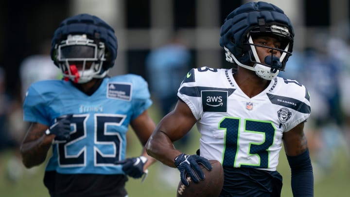 Seattle Seahawks wide receiver Easop Winston Jr. (13) runs after the catch when he beat Tennessee Titans running back Hassan Haskins (25) on the play at Ascension Saint Thomas Sports Park in Nashville, Tenn., Wednesday, Aug. 14 2024. This is the first day of the Titans joint practice with the Seattle Seahawks.