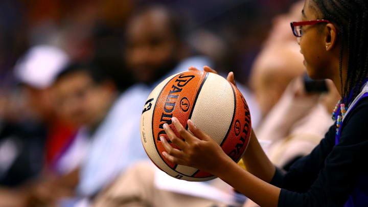 Sep 7, 2014; Phoenix, AZ, USA; A young female fan holds an official Spalding WNBA basketball during the game between the Phoenix Mercury against the Chicago Sky during game one of the WNBA Finals at US Airways Center. The Mercury defeated the Sky 83-62. Mandatory Credit: Mark J. Rebilas-Imagn Images
