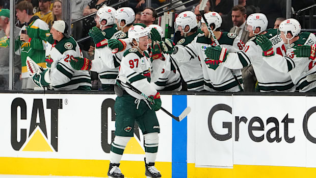 Hockey player in white uniform celebrates a goal score