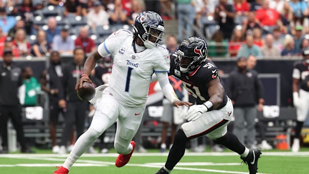 Sep 28, 2025; Houston, Texas, USA; Tennessee Titans quarterback Cam Ward (1) scrambles from Houston Texans defensive end Will